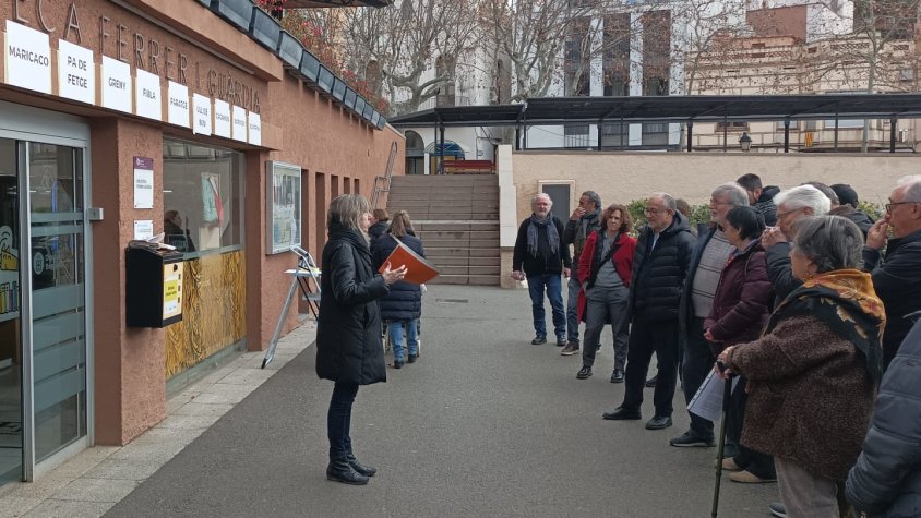 Participants del projecte Mots duran l'acte de retolació de les paraules seleccionades a la façana de la Biblioteca Ferrer i Guàrdia d'Alella
